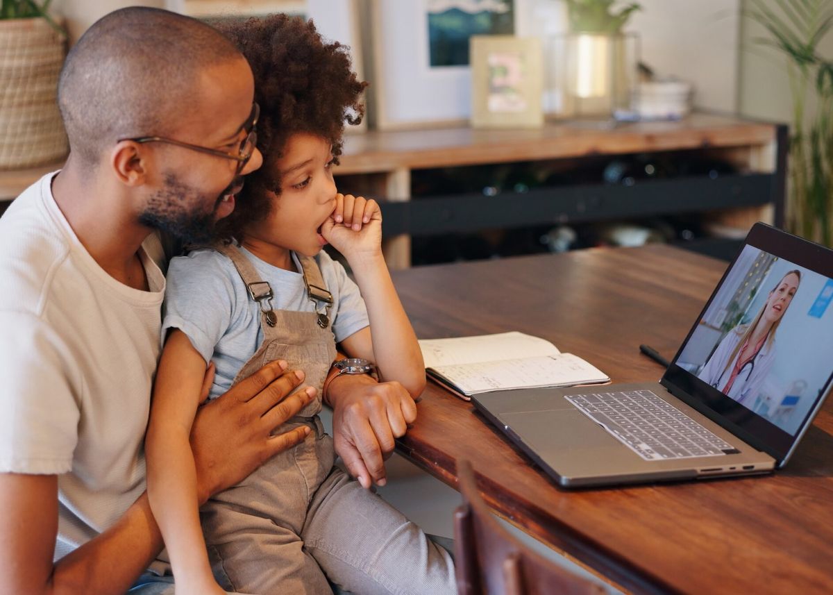 Child, black man and laptop screen with doctor for telehealth service, communication and advice. Home, boy and father with pediatrician on tech for medical support, discussion or virtual consultation.