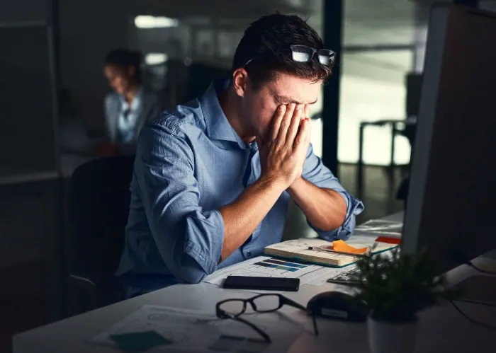 Shot of a young businessman working late at night in a modern office