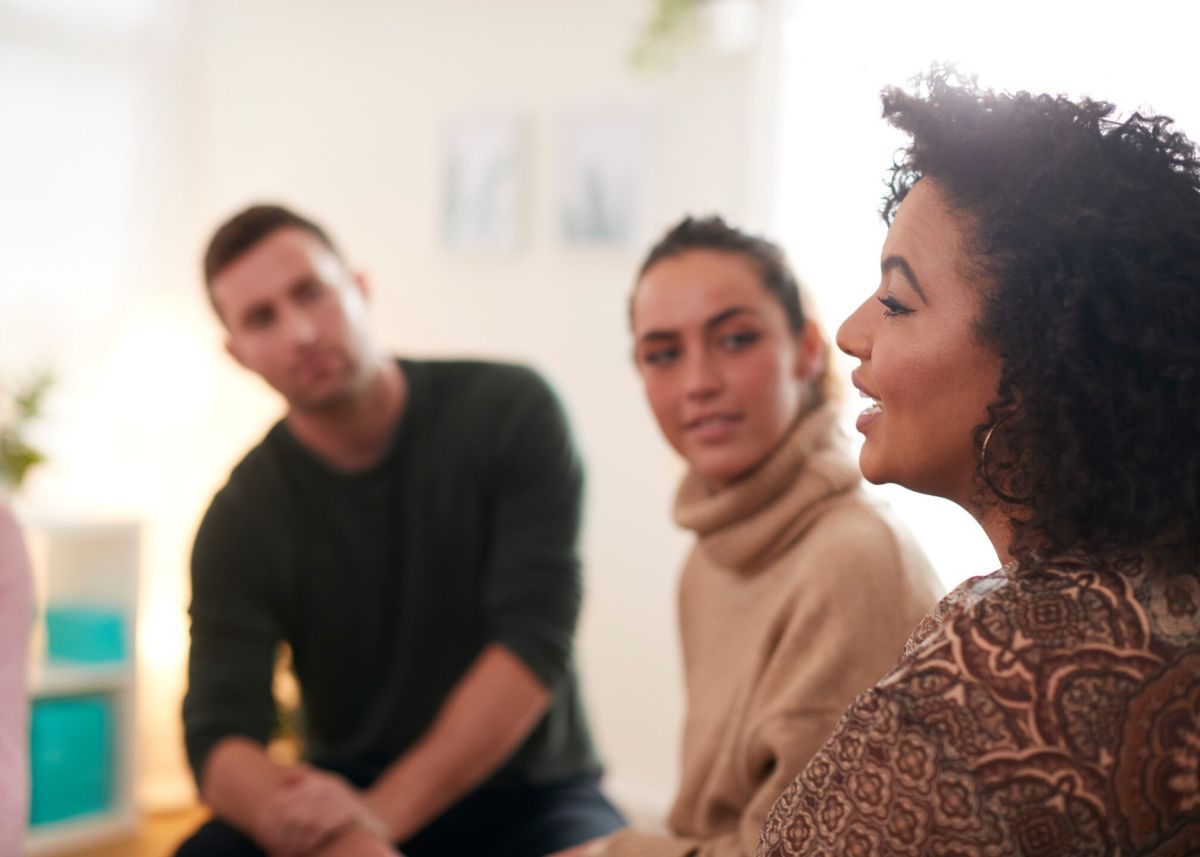 Woman Speaking At Support Group Meeting For Mental Health Or Dependency Issues In Community Space