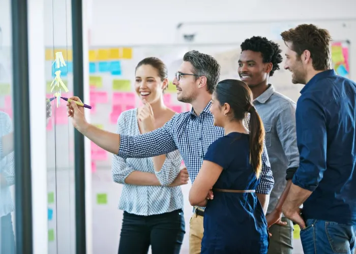 Discussion, glass wall and team of business people in office planning creative strategy for brand management. Meeting, ideas and group of public relations specialists by board for project at startup