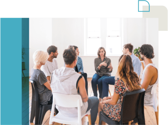 Image of 8 people sitting in a circle, one person is speaking and the rest are listening.