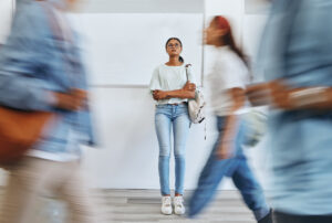 Student, anxiety and woman in busy college campus with depression, sad and mental health problems. Burnout, stress and tired girl thinking about exam, assignment or project deadline at university.