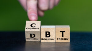 Cubes form the acronym CBT (Cognitive Behavioral Therapy) and DBT (Dialectical Behavior Therapy).