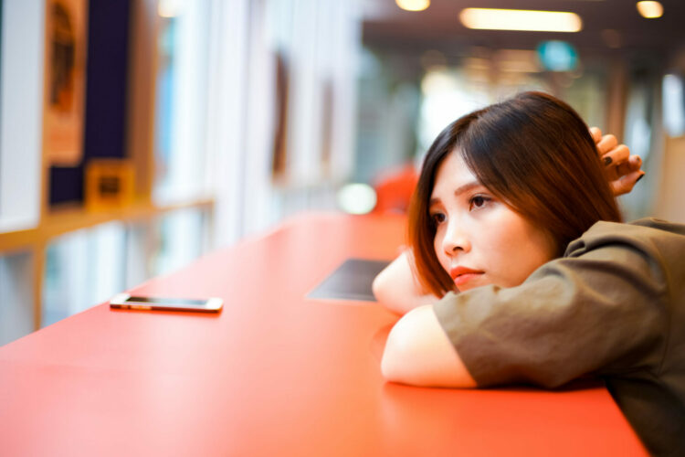 Lonely sad girl waiting for somebody and lying on the red table Lonely sad girl waiting for somebody and lying on the red table.