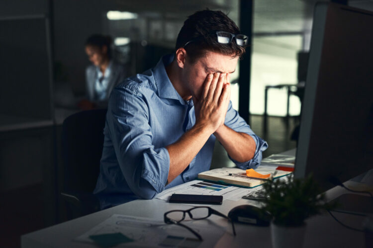 Shot of a young businessman working late at night in a modern office